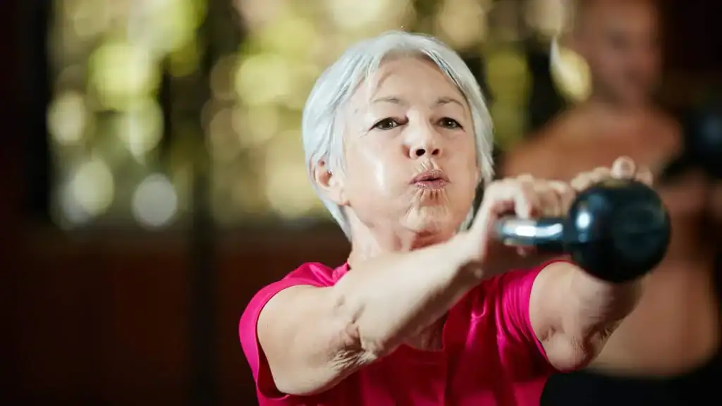 Toning Arms After 60: Empowering Womens Fitness Through Effective Weight Training 1 Older woman doing weight training Wokingham to help her strength and longevity